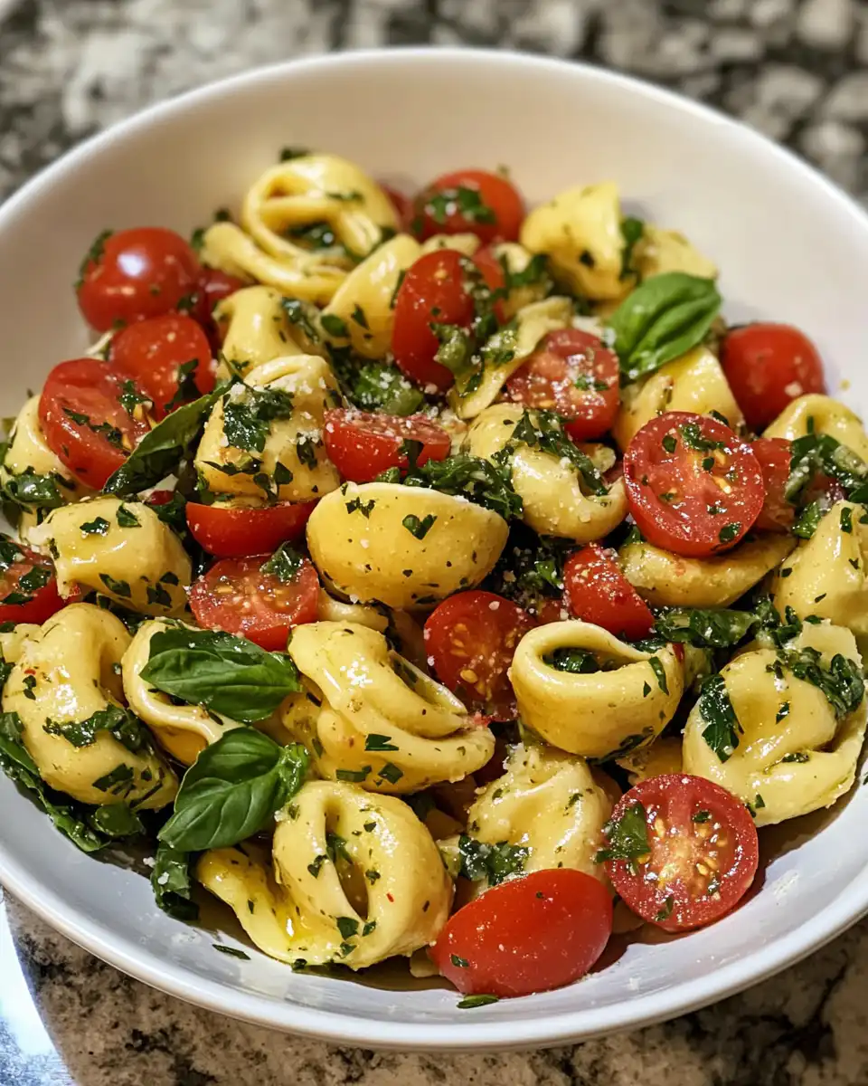 Ingredients for Italian Grinder Tortellini Salad laid out in bowl with meats and cheeses